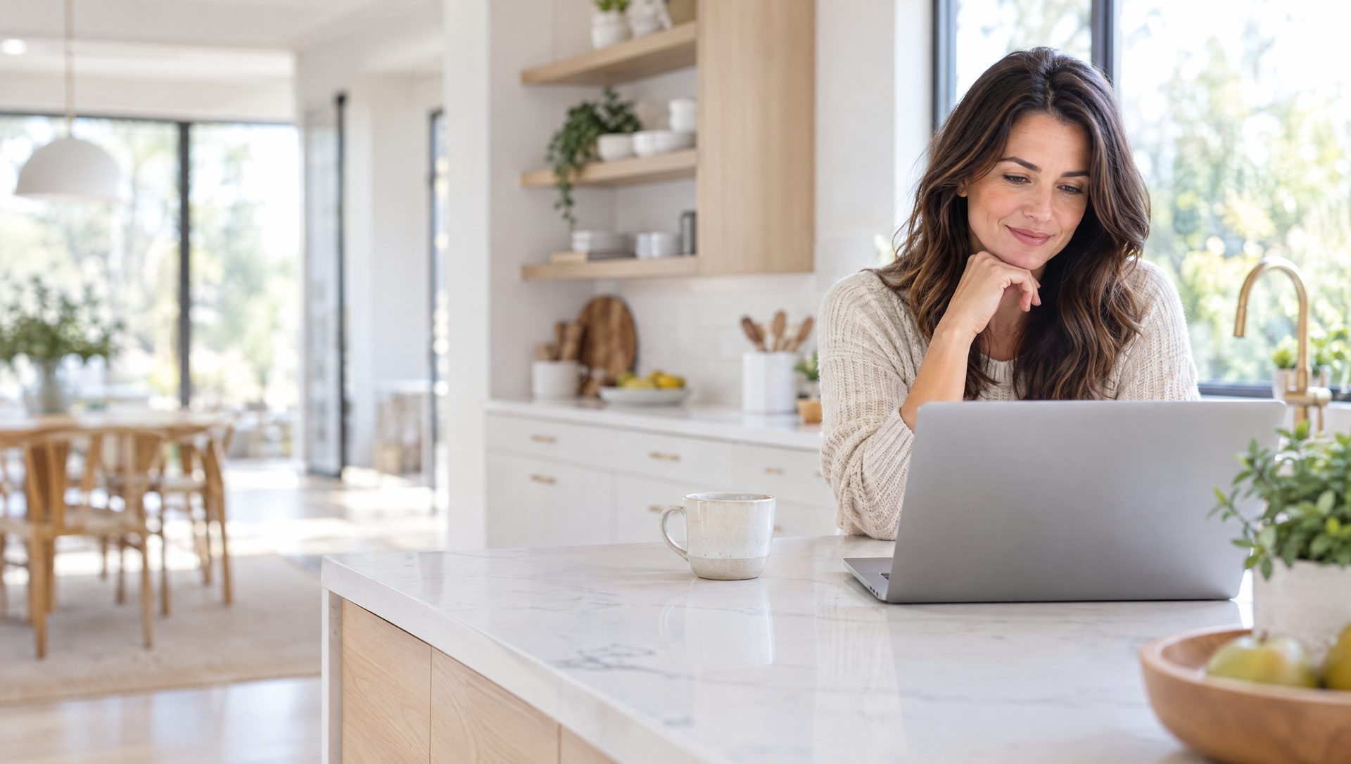 Homeowner comparing options on a laptop in a bright kitchen